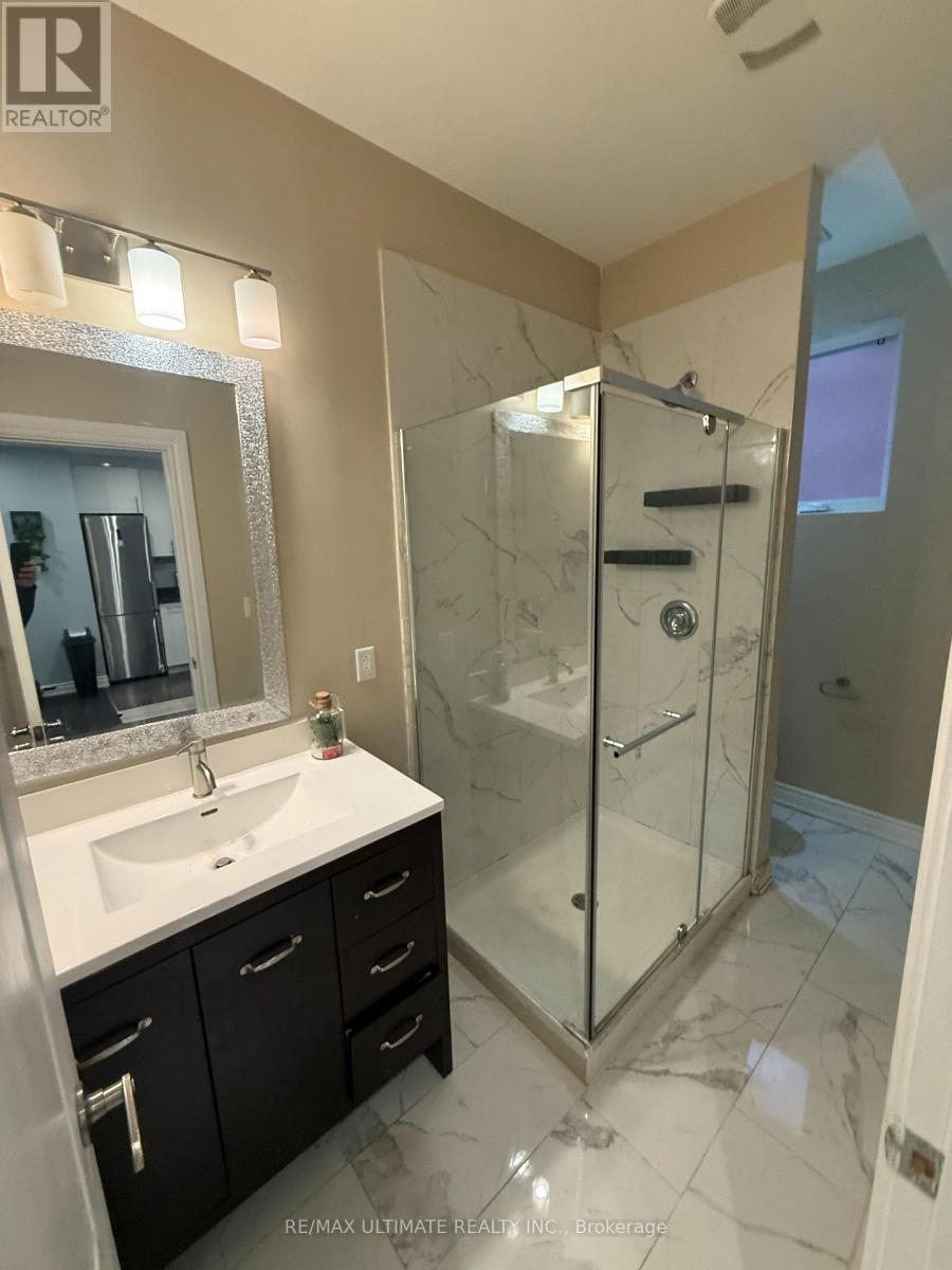 A bathroom with a sink, mirror, and shower.