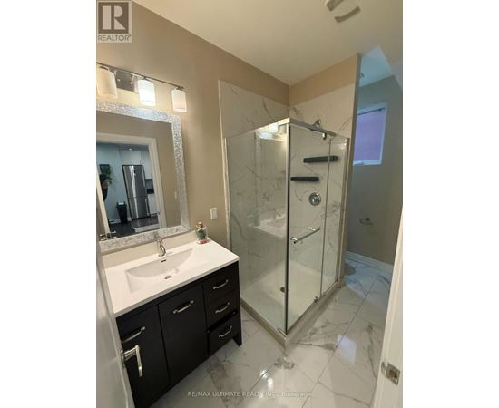 A bathroom with a sink, mirror, and shower.