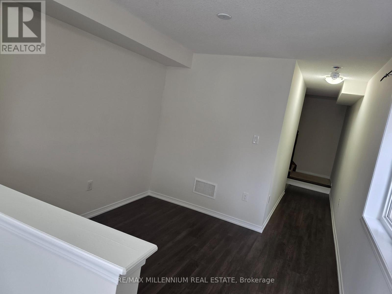 A room with a white wall and a wooden floor.