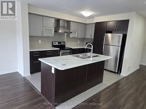 A kitchen with a white counter top and dark wood floors.