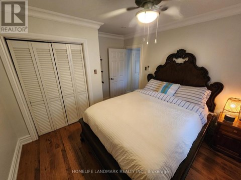 A bedroom with a large bed and a ceiling fan.