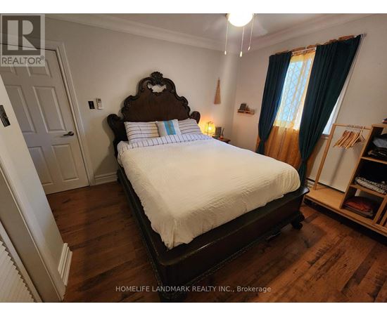 A bedroom with a large bed and a window with curtains.