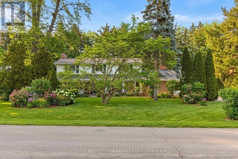 A house with a lawn and trees in front of it.