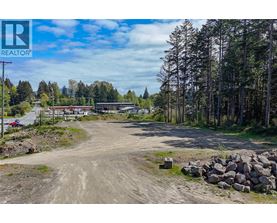 A dirt road leads to a building with a sign that says REALTOR.