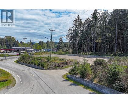 A road with a curve leading to a building with a sign that says REALTOR.
