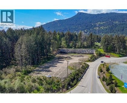 A realtor logo is on a picture of a wooded area.