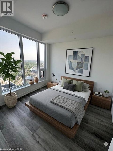 A bedroom with a large bed and a large window overlooking the city.