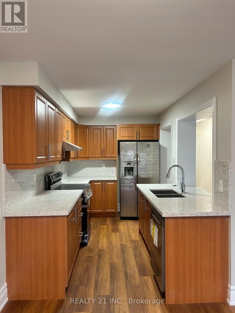 A kitchen with wooden cabinets and a granite countertop.