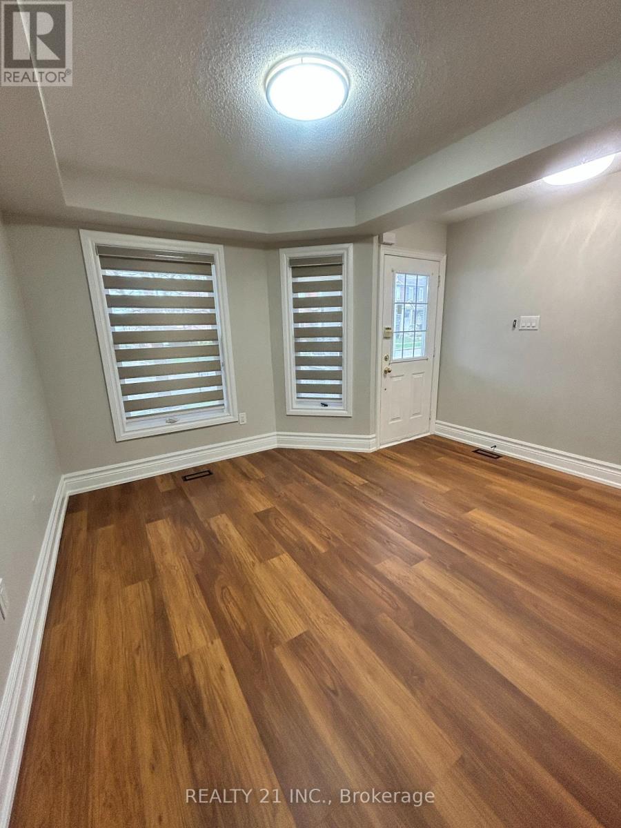 A room with wooden flooring and white walls.