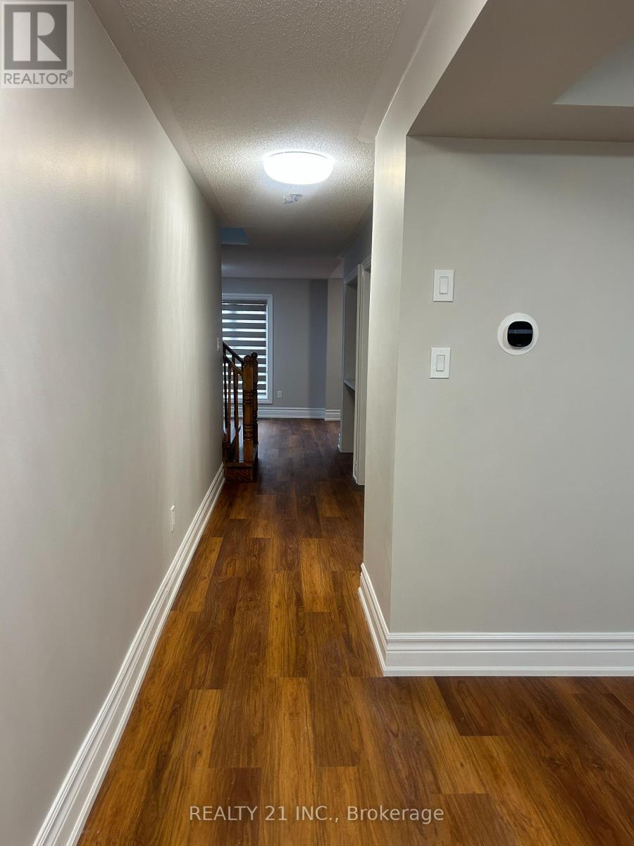 A hallway with wood floors and white walls.