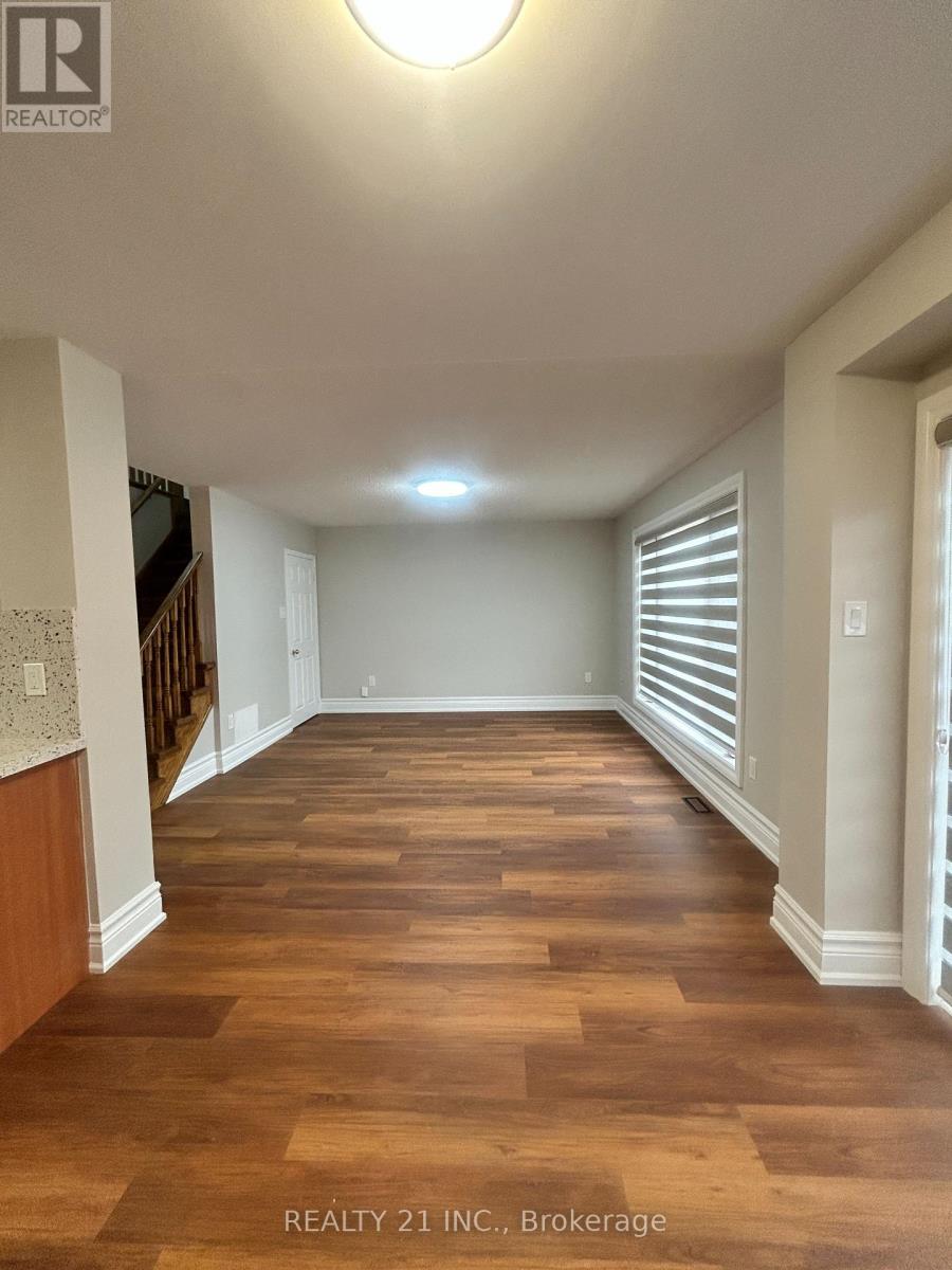 A long hallway with wood floors and white walls.