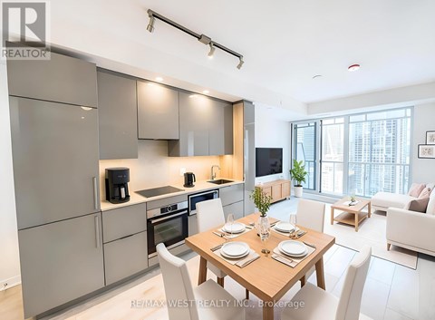 A modern kitchen with a dining table set for two.