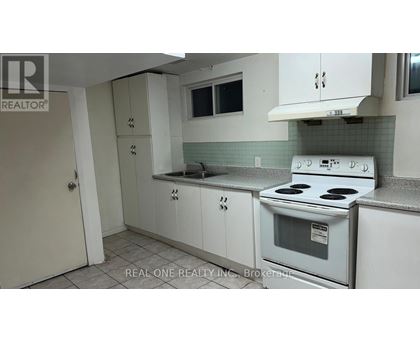 A white stove is in a kitchen with white cabinets.