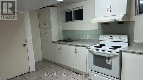 A white stove is in a kitchen with white cabinets.