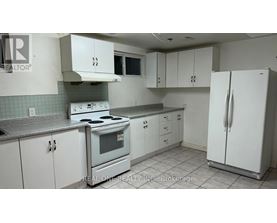 A kitchen with white cabinets and a stove top oven.