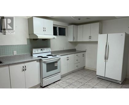 A kitchen with white cabinets and a stove top oven.