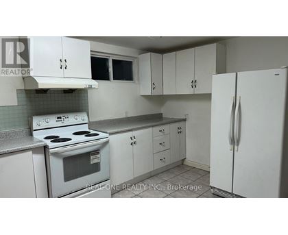 A white kitchen with a stove, oven, and refrigerator.
