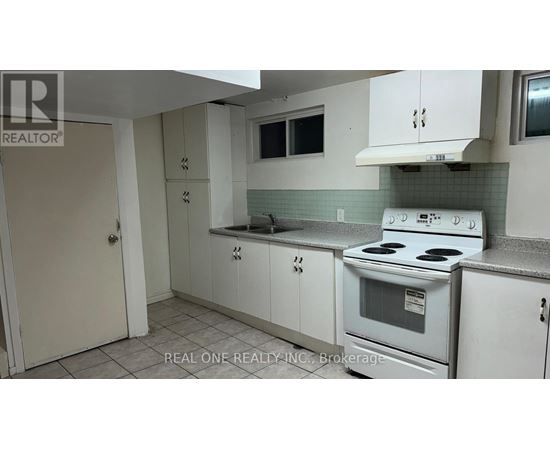 A white kitchen with a stove, sink, and cabinets.