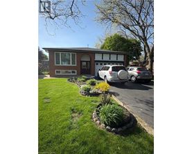 A house with a well-kept lawn and a car parked in front.