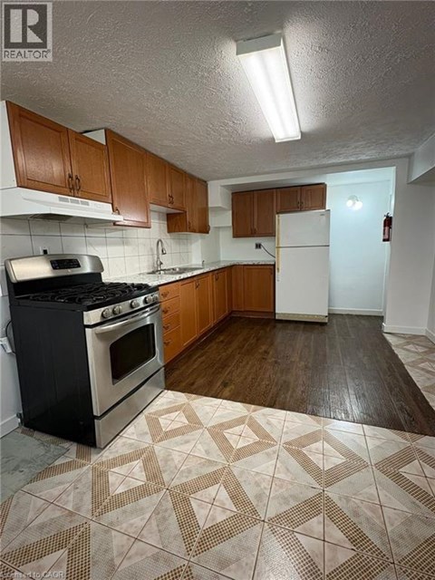 A kitchen with a black stove top oven and wooden cabinets.