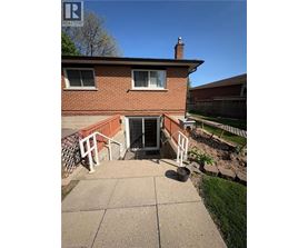 A house with a red brick exterior and a white fence.