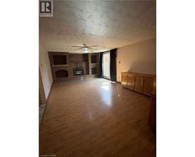 A living room with wooden floors and a brick fireplace.