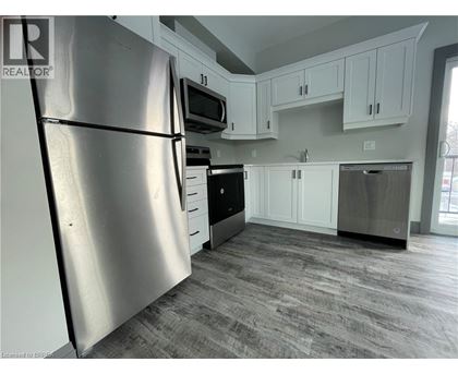 A kitchen with a refrigerator, microwave, oven, and dishwasher.