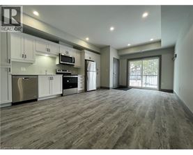 A spacious kitchen with stainless steel appliances and wooden flooring.