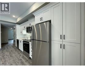 A modern kitchen with a stainless steel refrigerator and white cabinets.