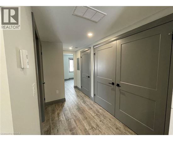 A hallway with a white door on the left and a grey door on the right.