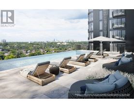 A poolside lounge area with chairs and a view of the city.