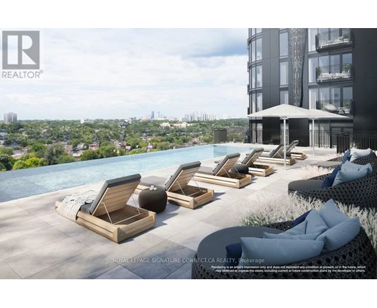 A poolside lounge area with chairs and a view of the city.