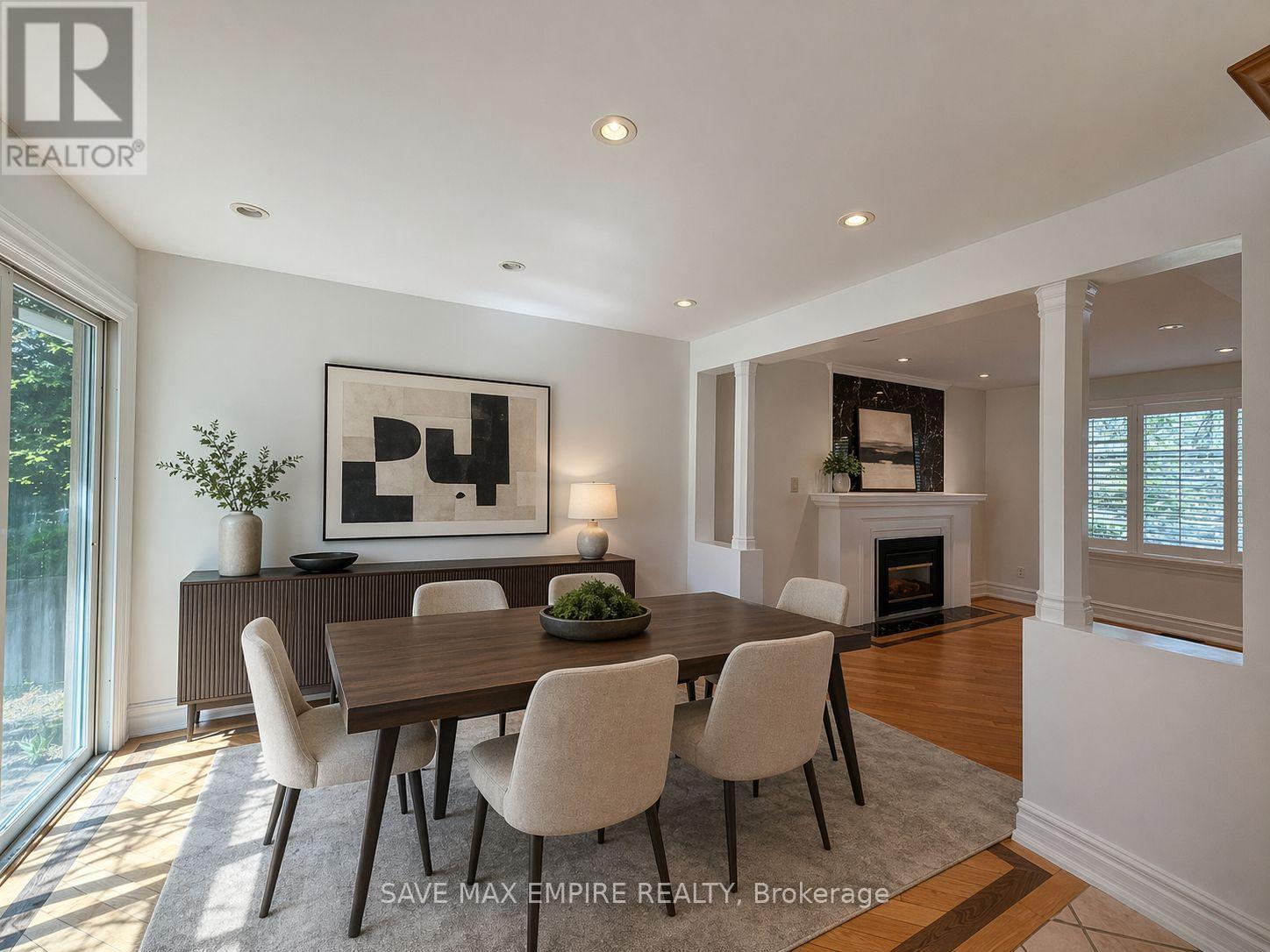 A dining room with a large table and chairs.