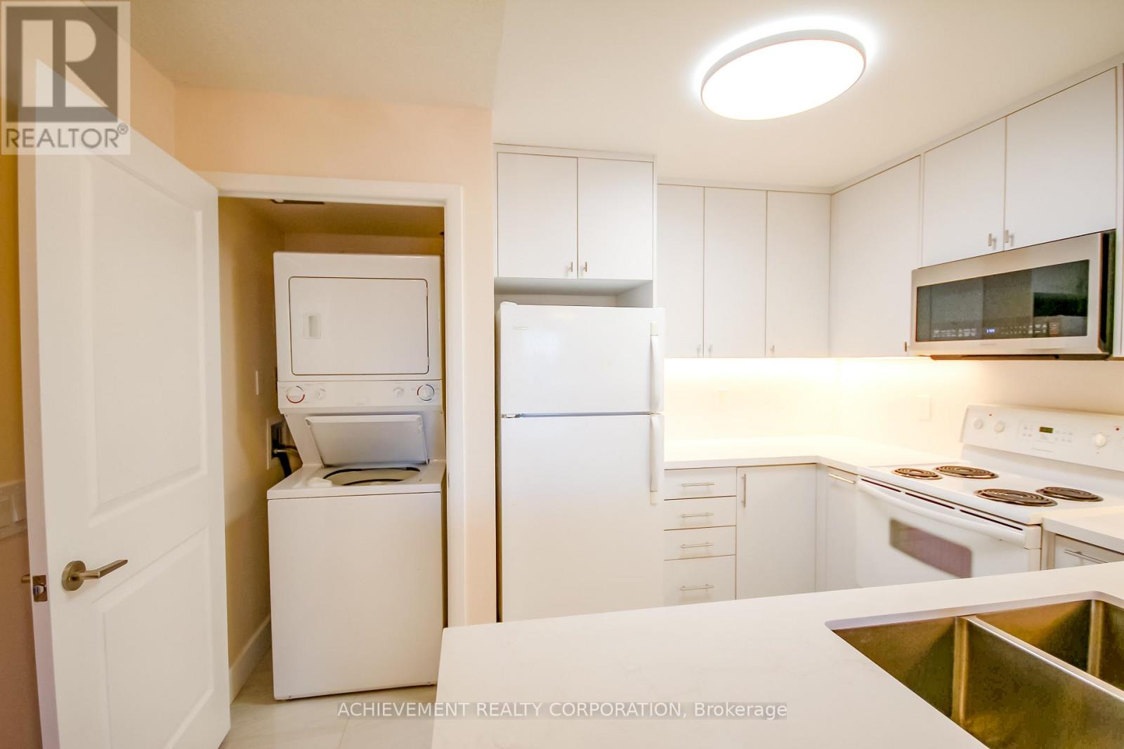 A kitchen with white appliances and cabinets.
