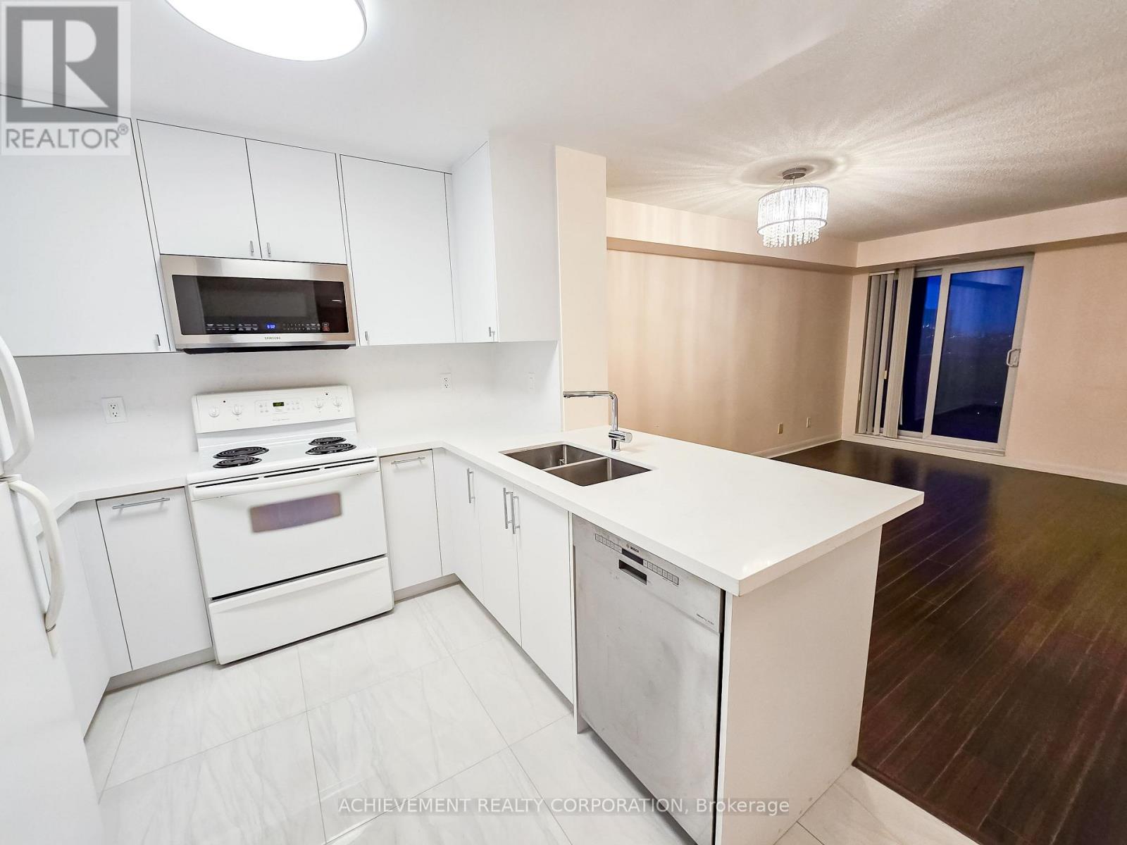 A white kitchen with a stove, oven, and microwave.