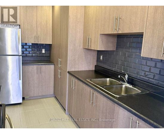 A kitchen with wooden cabinets and a black countertop.