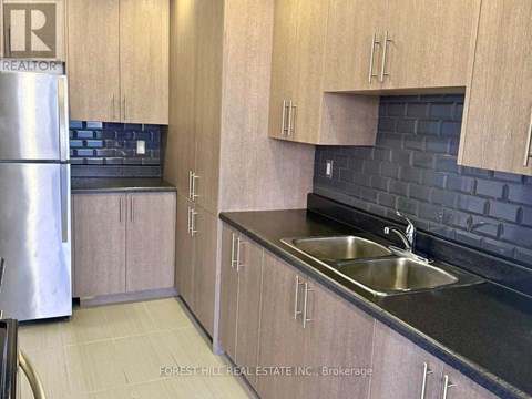 A kitchen with wooden cabinets and a black countertop.