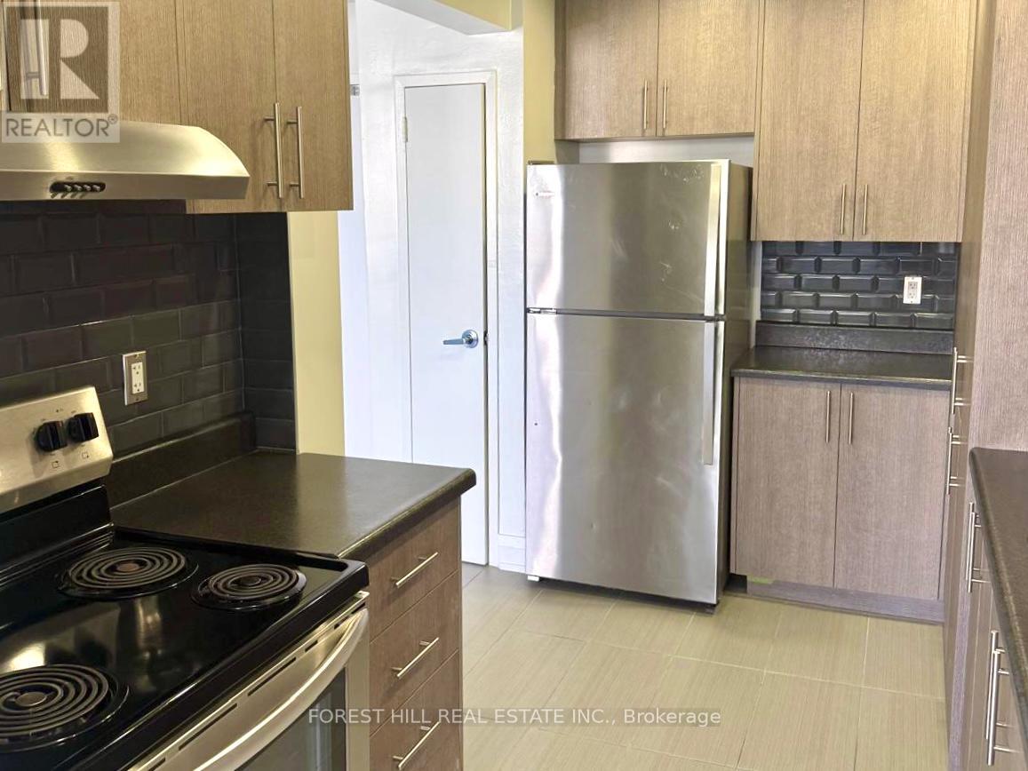 A kitchen with a stove top oven and a refrigerator.