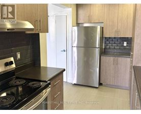 A kitchen with a stove top oven and a refrigerator.