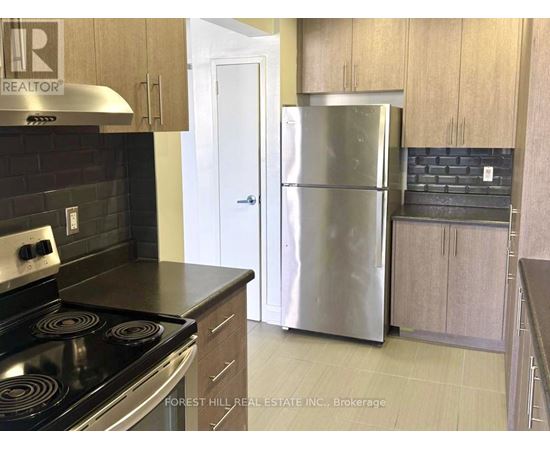 A kitchen with a stove top oven and a refrigerator.