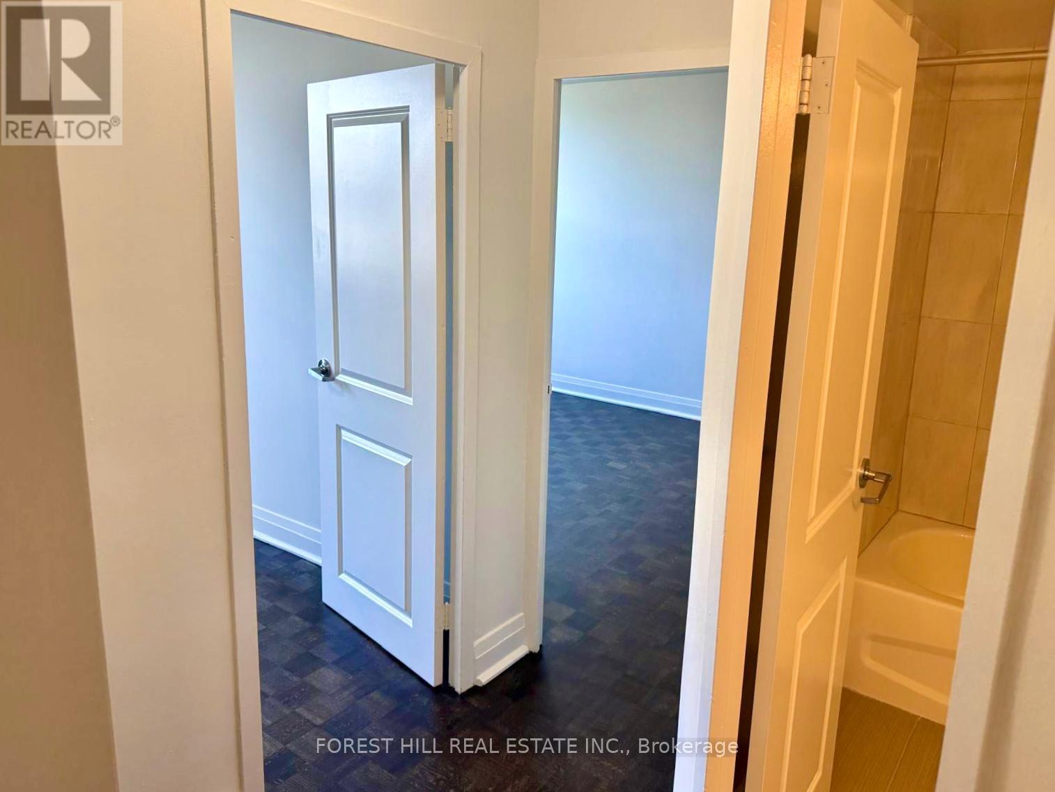 A hallway with a white door and a wooden door.