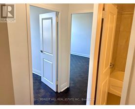 A hallway with a white door and a wooden door.