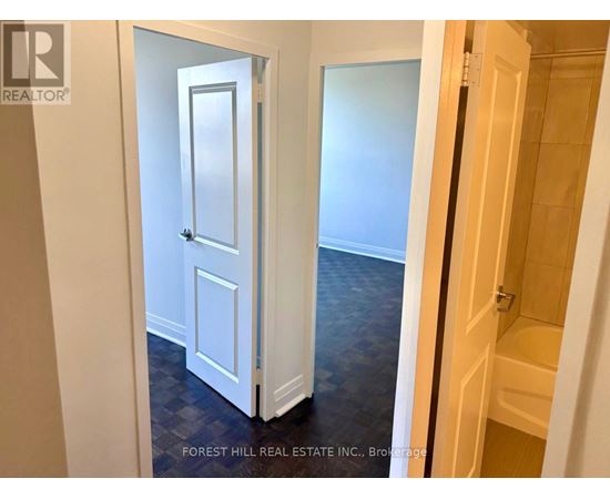 A hallway with a white door and a wooden door.