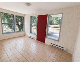 A room with a red door and tiled floor.