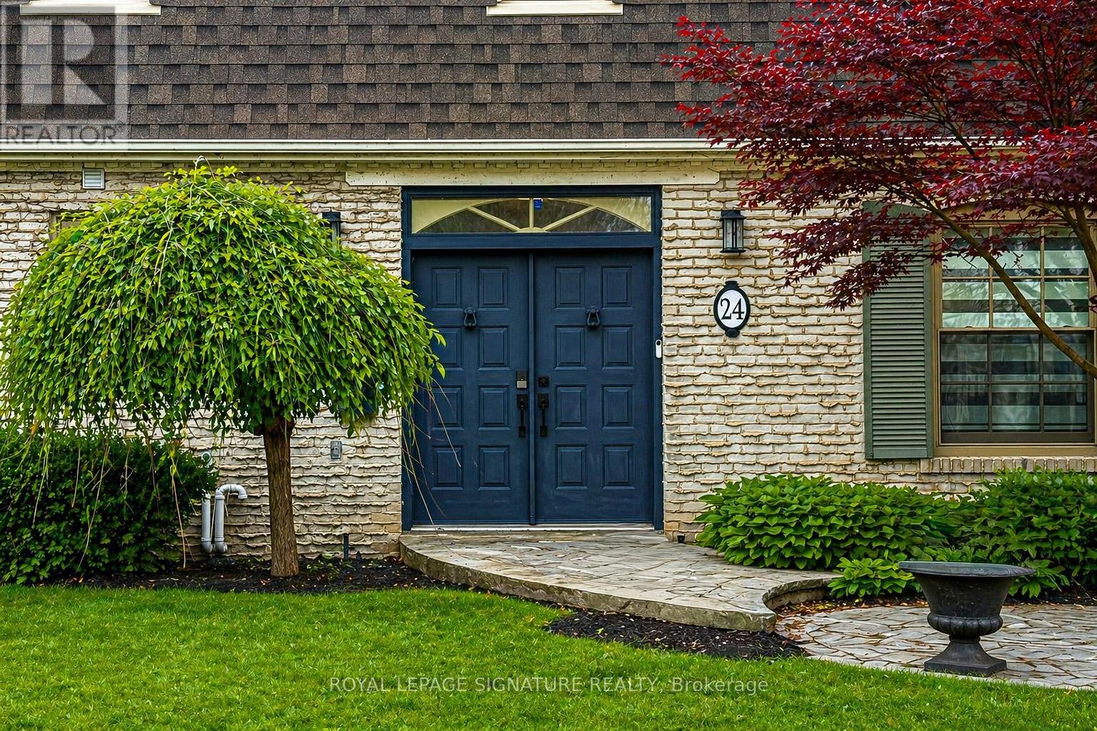 A house with a dark blue front door and a number 24 on the wall.