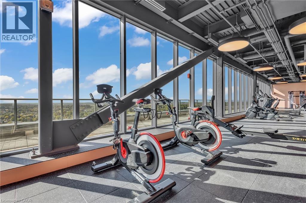 A gym with a row of stationary bikes and a large window.