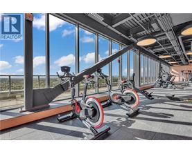 A gym with a row of stationary bikes and a large window.