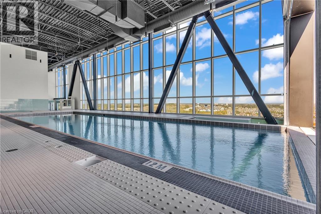 A large indoor swimming pool with a view of the sky through the windows.