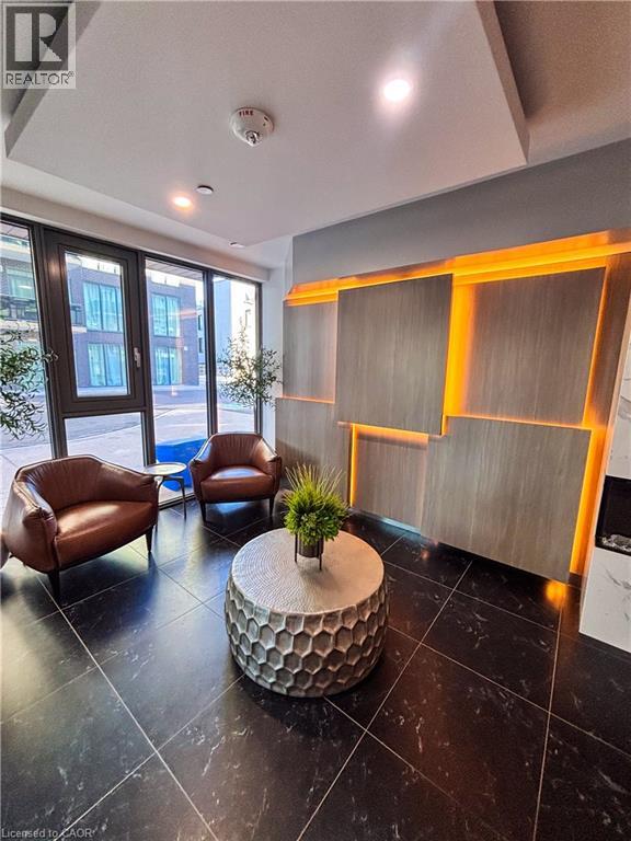 A living room with a brown leather chair and a round table with a plant on it.