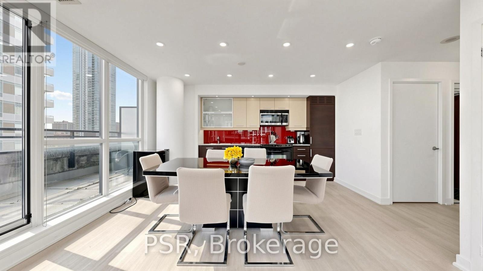 A modern dining room with a glass table and chairs.